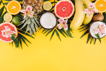 Obraz na płótnie Canvas Summer fruits. Tropical palm leaves, pineapple, coconut, grapefruit, orange and bananas on pink background. Flat lay, top view, copy space
