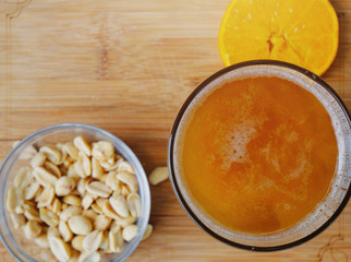 Flat lay of beer with salty peanuts and orange slice.  Relaxing adult beverage with copy space.