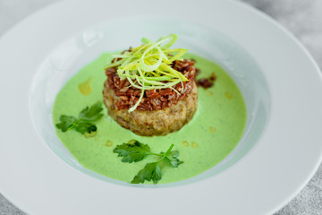 Meat dish with rice, onions slices, greens and sauce