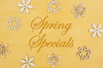 Fototapeta na wymiar Spring Specials message with wood flower petals on hand painted distressed gold