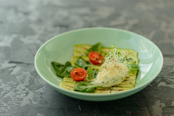 Salad from zucchini slices with cherry tomato, cream cheese and micro greens. Vegetarian food