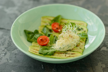 Salad from zucchini slices with cherry tomato, cream cheese and micro greens. Vegetarian food