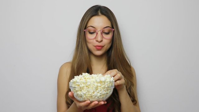 Young woman with glasses eating pop corn