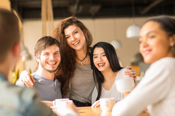 Happy friends hanging out at the cafe together