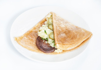 Thin delicious pancake with meat steak and mashed potatoes on white