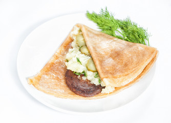 Thin delicious pancake with meat steak and mashed potatoes on white