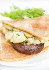 Thin delicious pancake with meat steak and mashed potatoes on white