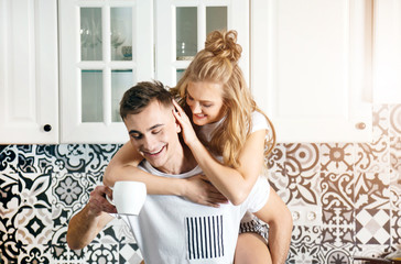 Obraz na płótnie Canvas Blonde man holding his woman while drinking worning coffee