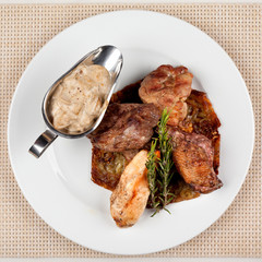 Fried meat in an assortment on a white plate with sauce.