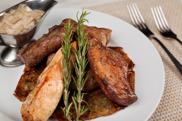 Fried meat in an assortment on a white plate with sauce.