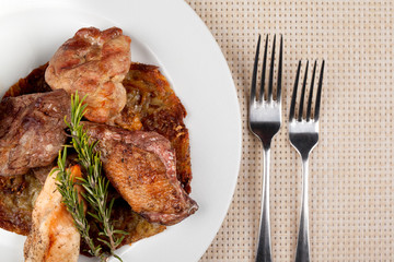 Fried meat in an assortment on a white plate with sauce.