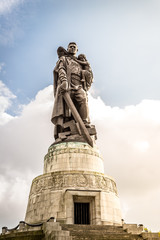 Soviet soldier holding at hands German child at Treptower park in Berlin