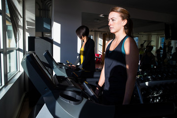 Women working out together on treadmill in gym
