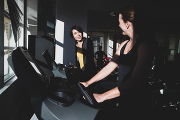 Fototapeta na wymiar Women working out together on treadmill in gym