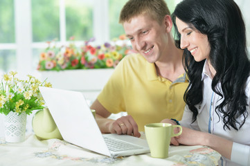 Portrait of happy young couple with laptop