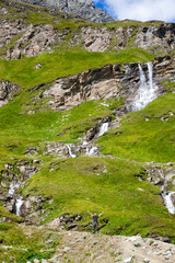 Fototapeta na wymiar A young man at the alpine waterfall