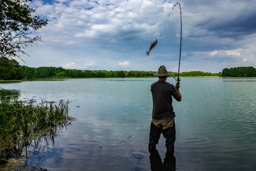 Angler catching the fish during an overcast day
