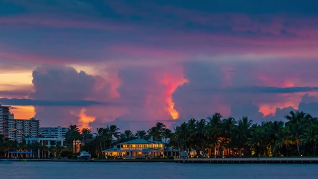 Epic storm tropical clouds thunderstorm lightning bolts over palm trees silhouettes resort landscape, sunset to night. 4K UHD Timelapse.