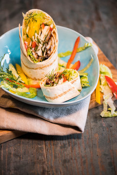 Wrap mit Gem&uuml;se und Fleisch auf Teller angerichtet.