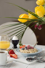 Breakfast oatmeal porridge with fruits berries and coffee cup. Oatmeal with strawberries and banana. Healthy breakfast concept.