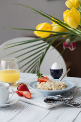 Breakfast oatmeal porridge with fruits berries and coffee cup. Oatmeal with strawberries and banana. Healthy breakfast concept.