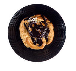 Chocolate eclair on a plate isolated on white background.