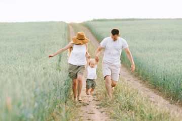 Fototapeta premium A young family have a fun with their little baby in the field