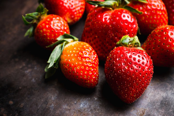 Fresh ripe strawberry on the dark rustic background. Selective focus. Shallow depth of field.