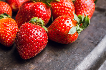 Fresh ripe strawberry on the dark rustic background. Selective focus. Shallow depth of field.