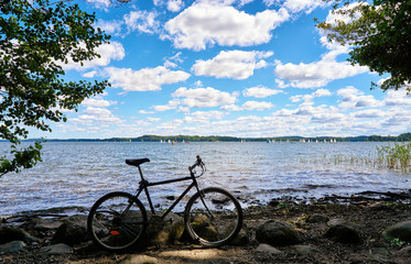 Bicycle at Schwerin lake with sailing yacht race in the background. Mecklenburg-Vorpommern, Germany