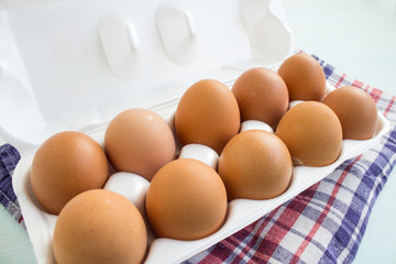 Fresh farm eggs in a pan on the kitchen table. Brown organic eggs. Close-up.