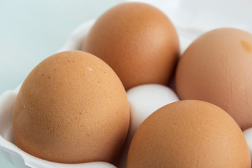 Fresh farm eggs in a pan on the kitchen table. Brown organic eggs. Close-up.