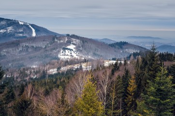 Beautiful winter cloudy landscape. Snow-covered mountain slopes in the Polish mountains.