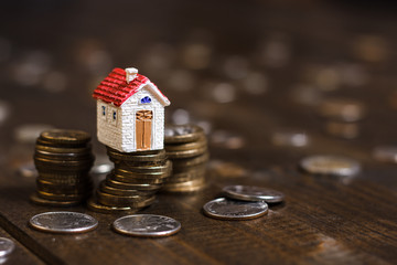 Model house on stack of coins. Concept of Investment management