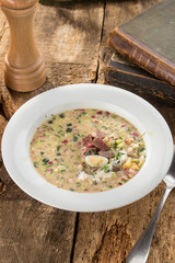 Summer cold soup okroshka with radish, cucumber and beef on wooden board
