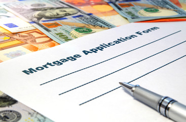 Mortgage application form with a pen and money.