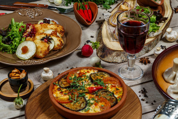 View from above of georgian cuisine on brown wooden table. Traditional georgian cuisine and food - khinkali, kharcho, chahokhbili, phali, lobio and local sauces - tkemali, satsebeli, adzhika. Top view
