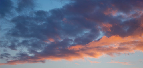 Blue and orange clouds in the sky during the sunset. Evening sky