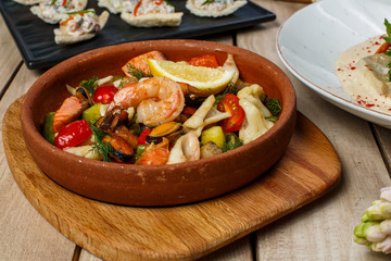 View from above of georgian cuisine on brown wooden table. Traditional georgian cuisine and food - khinkali, kharcho, chahokhbili, phali, lobio and local sauces - tkemali, satsebeli, adzhika. Top view