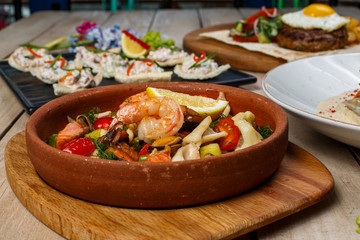 View from above of georgian cuisine on brown wooden table. Traditional georgian cuisine and food - khinkali, kharcho, chahokhbili, phali, lobio and local sauces - tkemali, satsebeli, adzhika. Top view
