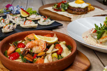 View from above of georgian cuisine on brown wooden table. Traditional georgian cuisine and food - khinkali, kharcho, chahokhbili, phali, lobio and local sauces - tkemali, satsebeli, adzhika. Top view