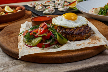 View from above of georgian cuisine on brown wooden table. Traditional georgian cuisine and food - khinkali, kharcho, chahokhbili, phali, lobio and local sauces - tkemali, satsebeli, adzhika. Top view