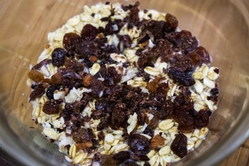 Oat flakes in the bowl with rozins and nuts and plant milk. Slovakia