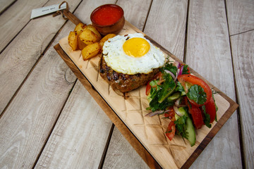 View from above of georgian cuisine on brown wooden table. Traditional georgian cuisine and food - khinkali, kharcho, chahokhbili, phali, lobio and local sauces - tkemali, satsebeli, adzhika. Top view