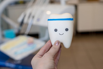 Toy model of tooth with cute face.orthodontic model and dentist tool - demonstration teeth model of varities of orthodontic bracket or brace.Healthy tooth. healthy eating concept.dental visit