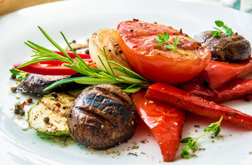Assorted delicious grilled meat with vegetable and herbs on rustic table