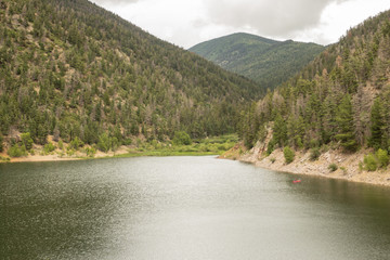 tiny boat on a huge lake surrounded by mountains in New Mexico 