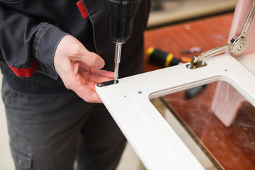 Carpenter working on white color play kitchen oven door