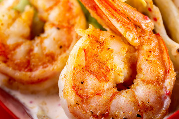 Macro image of grilled prawns with spices and sauce.