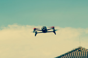 Drone flying overhead in cloudy blue sky